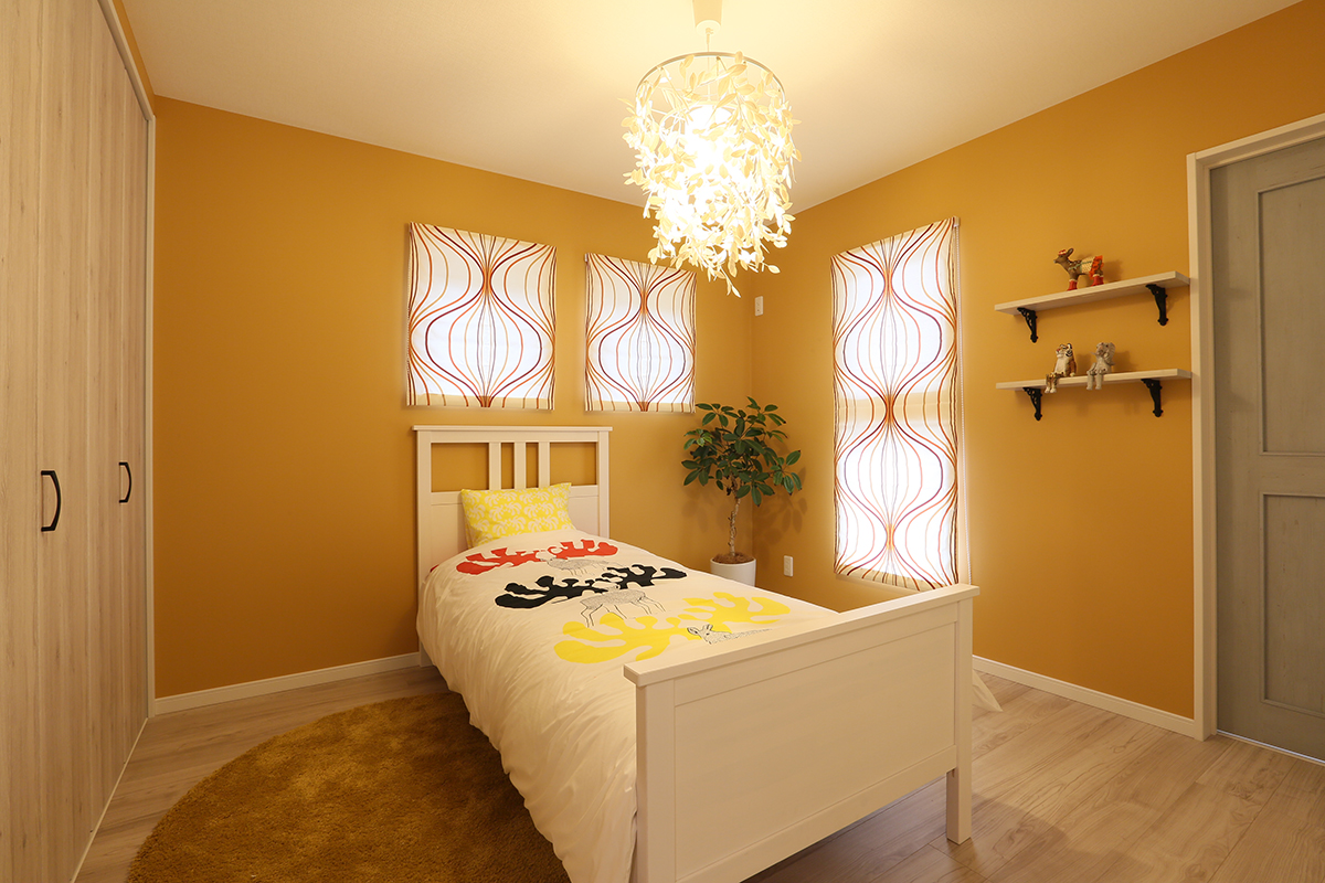 木目とオレンジの組み合わせの寝室